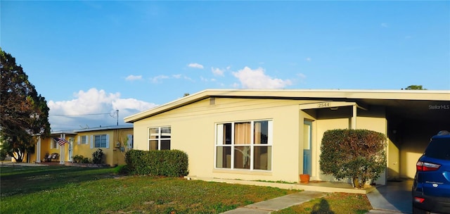 view of side of home featuring a yard and a carport