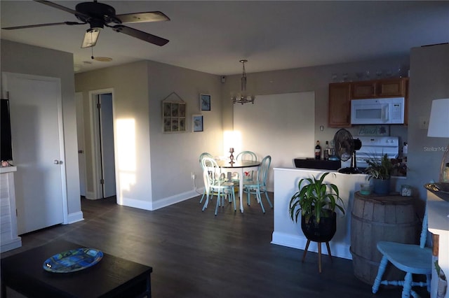 kitchen featuring dark hardwood / wood-style floors, white appliances, decorative light fixtures, and ceiling fan with notable chandelier