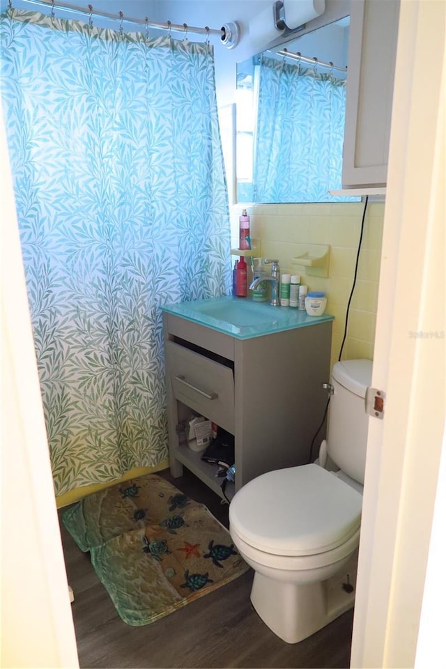 bathroom featuring hardwood / wood-style flooring, vanity, tile walls, and toilet