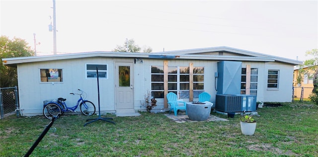 back of house featuring central AC and a lawn