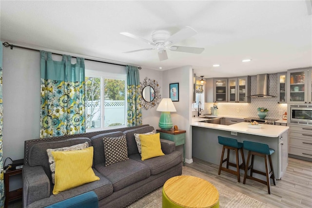 living room with ceiling fan and light wood-type flooring