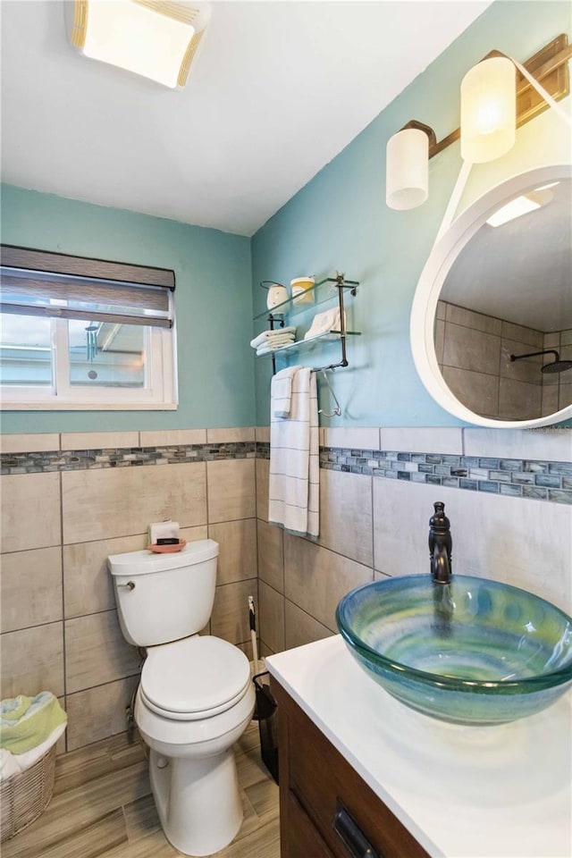 bathroom with hardwood / wood-style floors, vanity, tile walls, and toilet