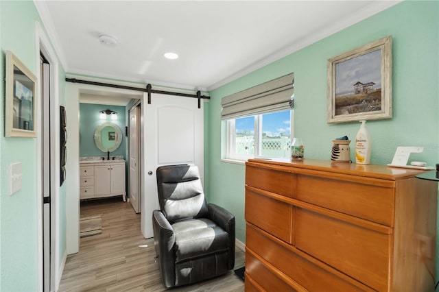 living area featuring crown molding, a barn door, and light hardwood / wood-style floors