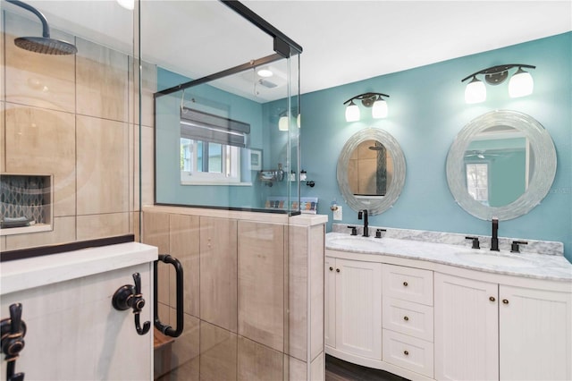 bathroom featuring a shower with door and vanity