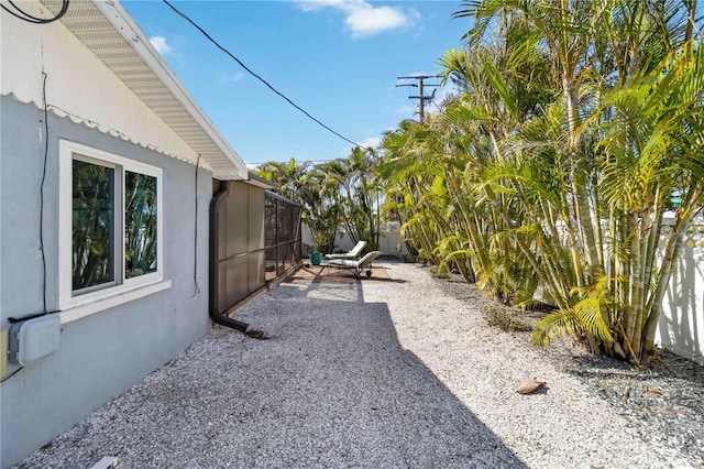 view of yard with a patio area and glass enclosure