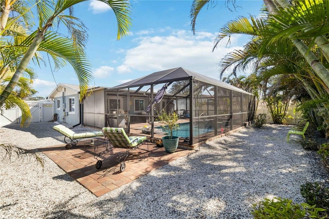 exterior space featuring a fenced in pool and glass enclosure