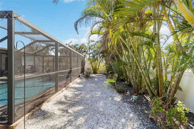 view of yard featuring a patio area and glass enclosure