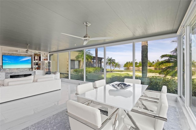 sunroom featuring ceiling fan and plenty of natural light