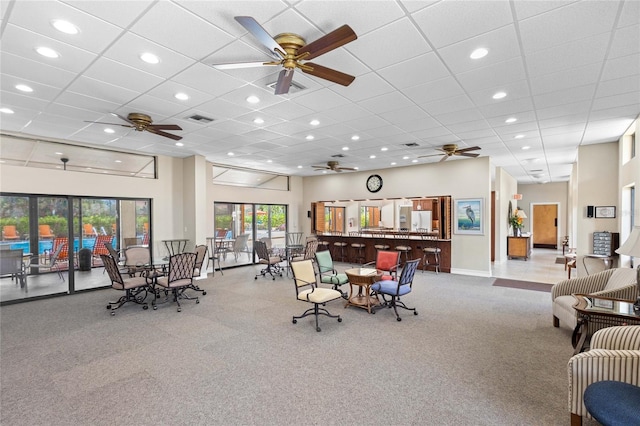 interior space featuring a towering ceiling, a drop ceiling, and ceiling fan