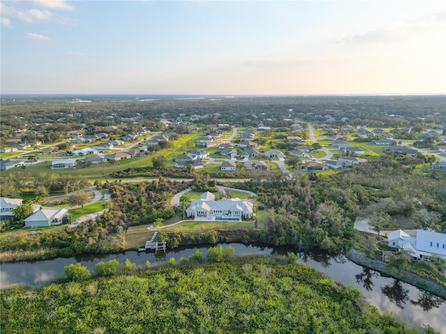 aerial view at dusk featuring a water view