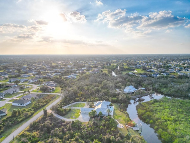 aerial view at dusk featuring a water view