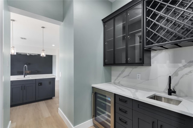 bar featuring wine cooler, hanging light fixtures, tasteful backsplash, and sink