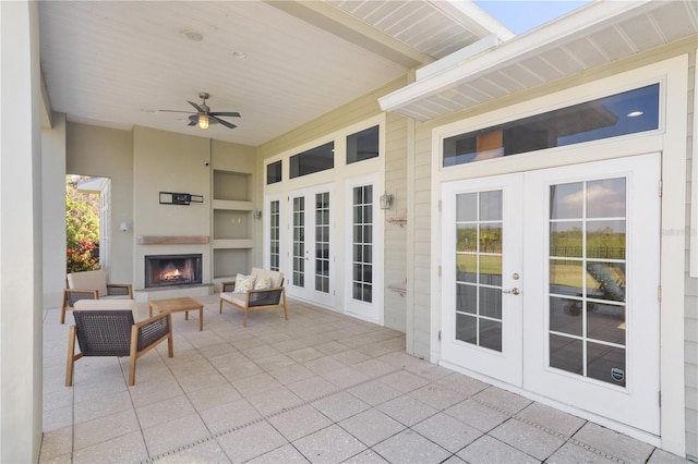 view of patio featuring ceiling fan, exterior fireplace, and french doors