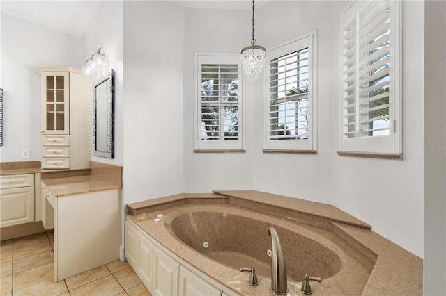 bathroom featuring vanity, a bath, tile patterned flooring, and an inviting chandelier