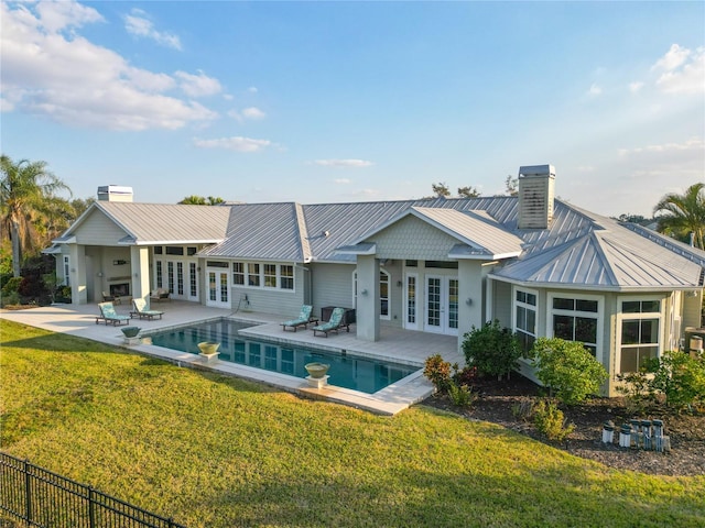 back of house with a fenced in pool, a patio area, french doors, and a lawn