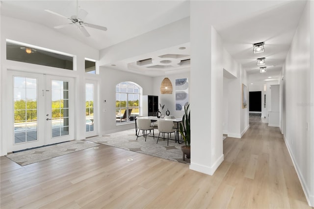 interior space with french doors, ceiling fan, coffered ceiling, and light hardwood / wood-style floors