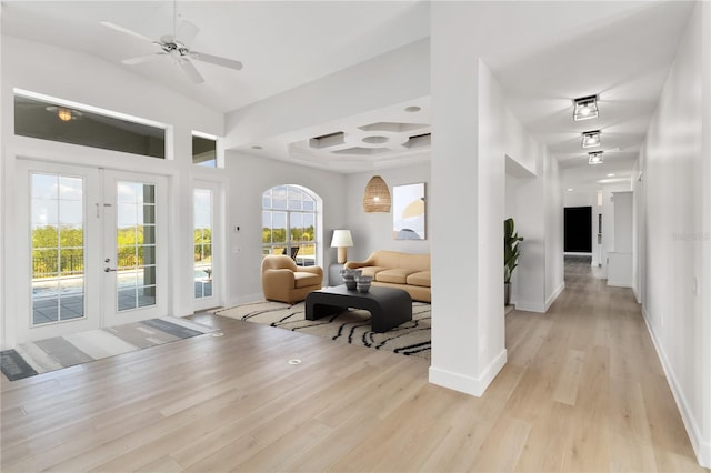 foyer entrance featuring french doors, coffered ceiling, ceiling fan, and light hardwood / wood-style flooring