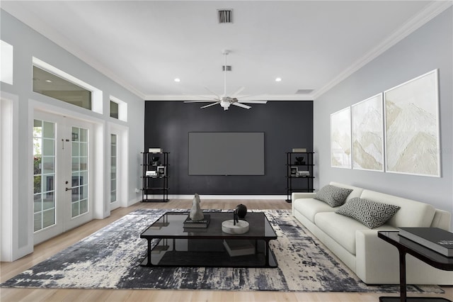 living room featuring ornamental molding, light hardwood / wood-style floors, ceiling fan, and french doors