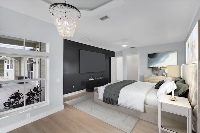 bedroom featuring a notable chandelier and light hardwood / wood-style flooring