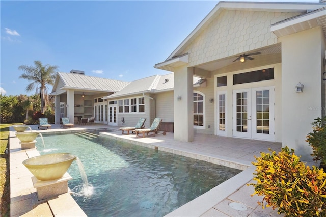 view of pool with pool water feature, ceiling fan, a patio area, and french doors