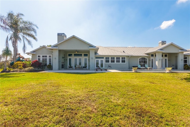 back of property featuring a lawn, french doors, and a patio area