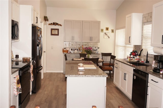 kitchen with white cabinetry, a kitchen island, sink, and black appliances