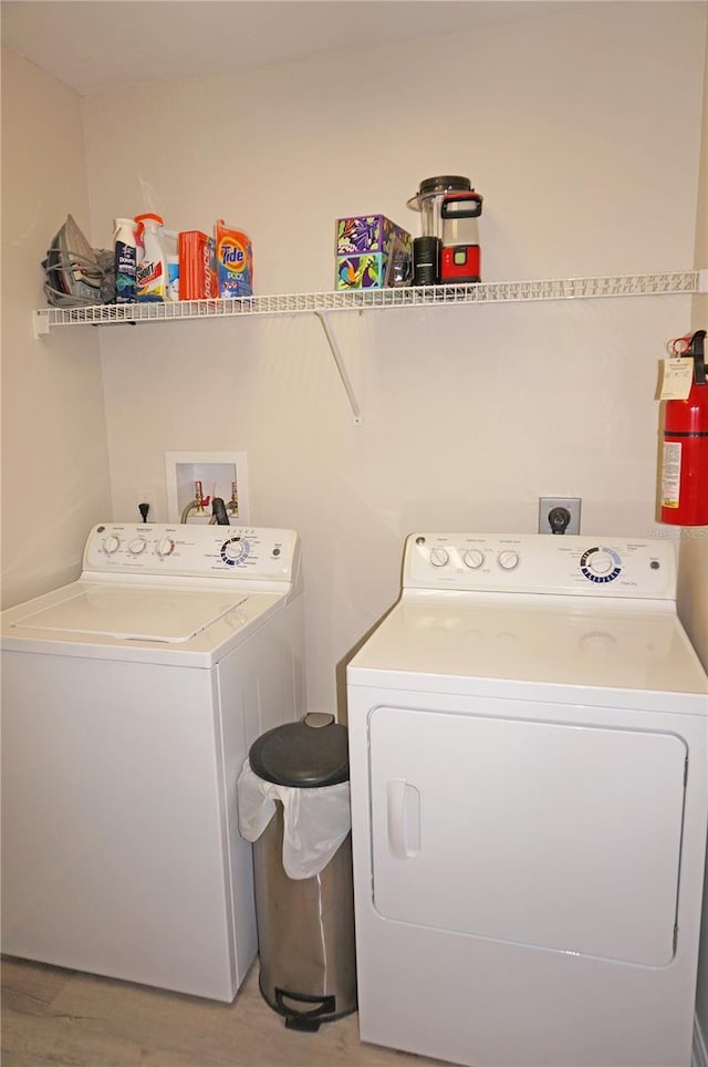 laundry area featuring separate washer and dryer and light hardwood / wood-style flooring