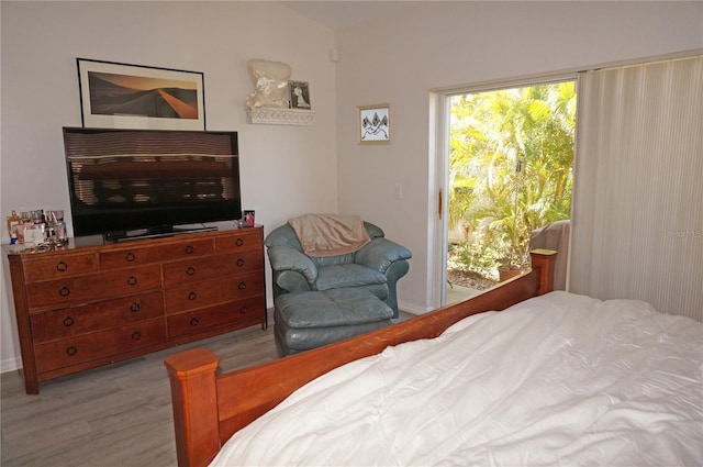 bedroom with access to exterior and light hardwood / wood-style floors