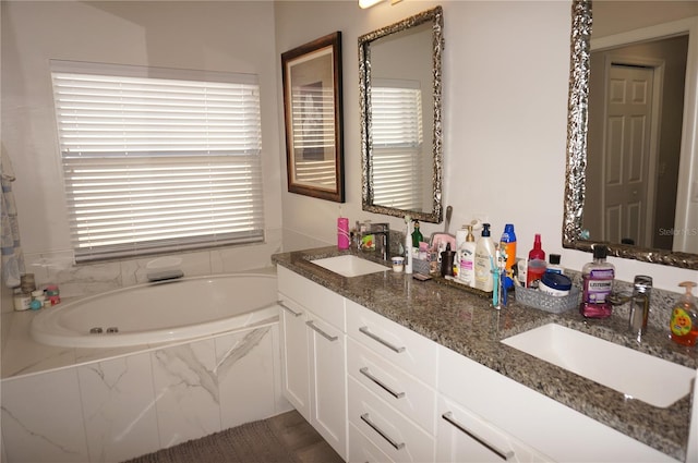 bathroom with vanity and a relaxing tiled tub