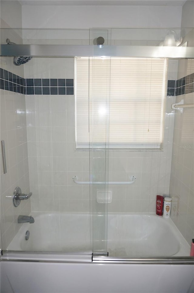 bathroom featuring bath / shower combo with glass door