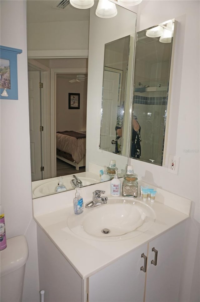 bathroom with toilet, vanity, and walk in shower