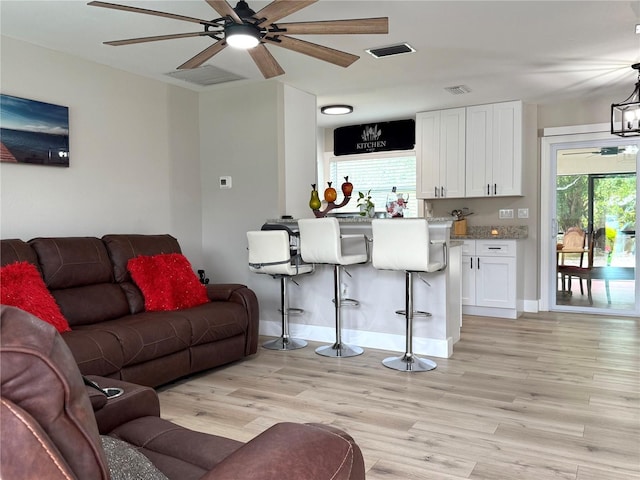 living room featuring light hardwood / wood-style flooring and ceiling fan