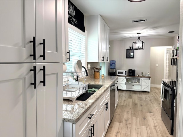 kitchen featuring range with electric stovetop, white cabinetry, dishwasher, and pendant lighting