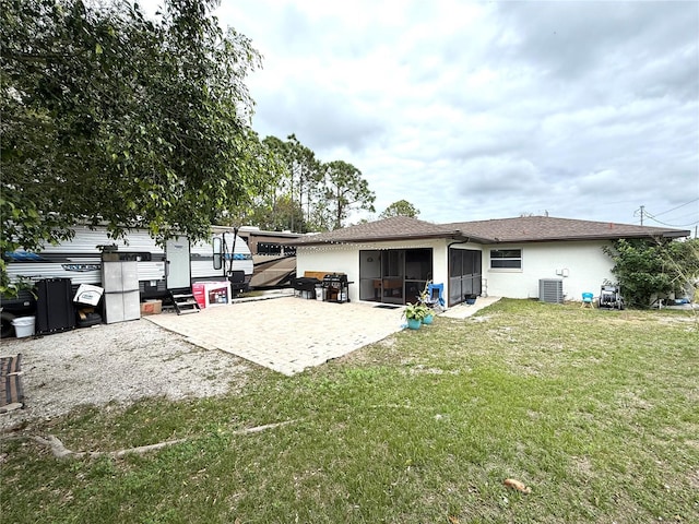 back of house featuring a yard, a sunroom, and a patio