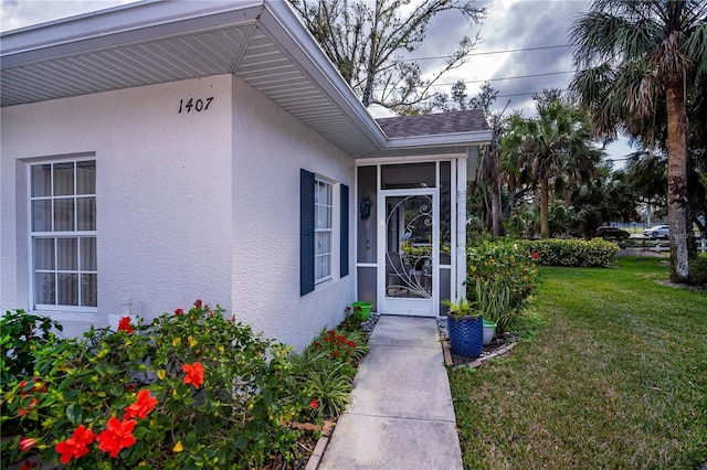 view of exterior entry featuring a yard