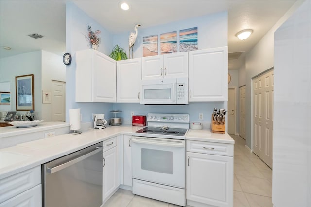 kitchen with white cabinetry, white appliances, and light tile patterned floors