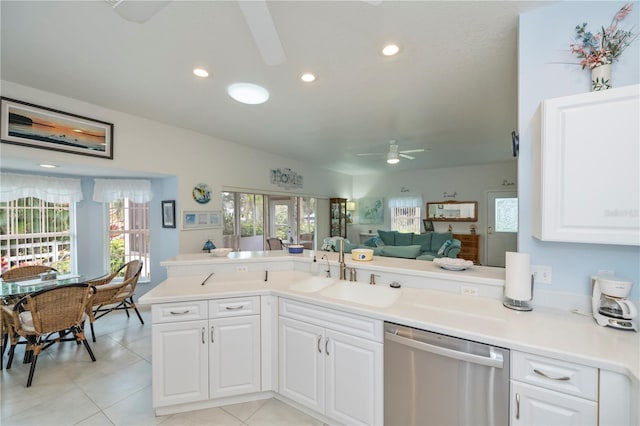 kitchen featuring dishwasher, sink, white cabinets, light tile patterned floors, and kitchen peninsula