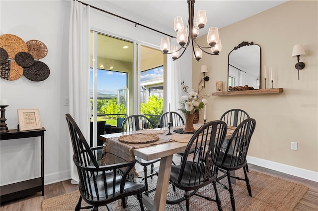 dining space with wood-type flooring and a chandelier