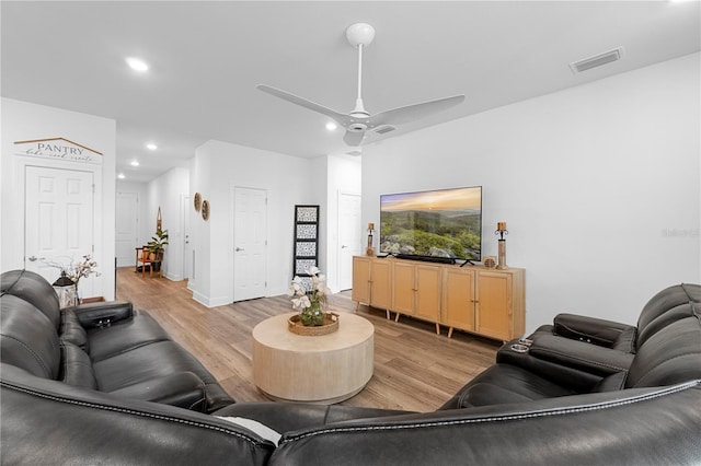 living room featuring ceiling fan and light hardwood / wood-style flooring