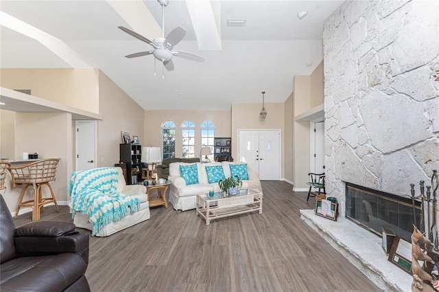 living room featuring ceiling fan, wood-type flooring, a fireplace, and high vaulted ceiling