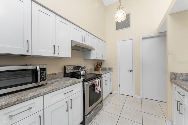 kitchen featuring white cabinetry, light tile patterned floors, stainless steel appliances, and light stone countertops