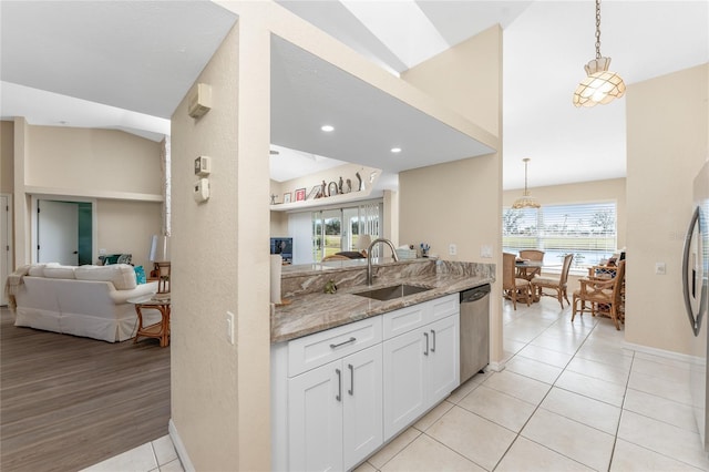 kitchen with lofted ceiling, sink, dishwasher, white cabinetry, and light stone counters