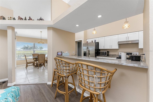 kitchen featuring white cabinetry, appliances with stainless steel finishes, kitchen peninsula, and pendant lighting