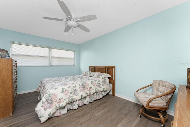 bedroom featuring multiple windows, dark hardwood / wood-style floors, and ceiling fan