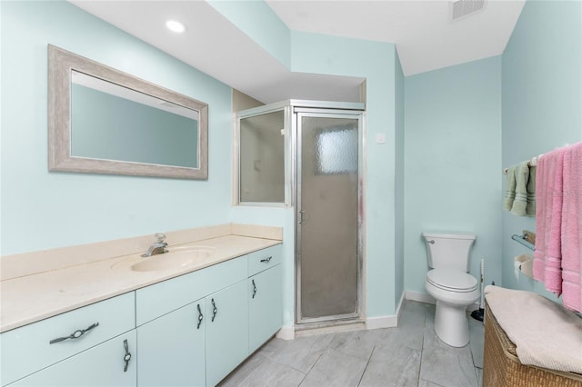 bathroom with vanity, toilet, and a shower with door