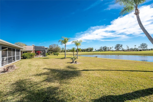 view of yard featuring a water view and a sunroom