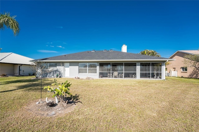 back of property featuring a sunroom and a lawn