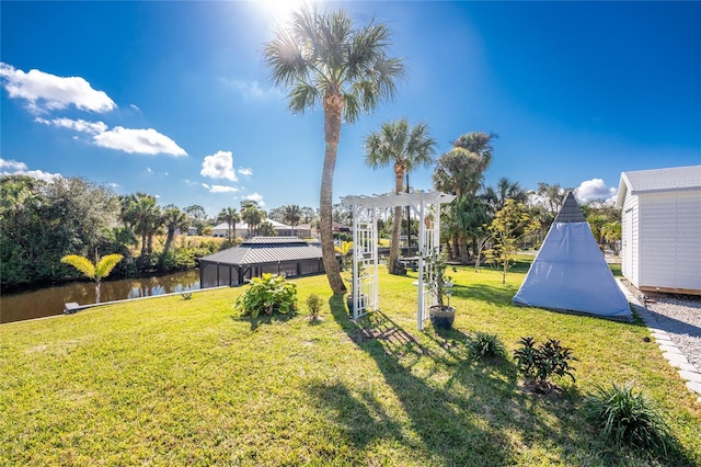 view of yard featuring a water view and a pergola