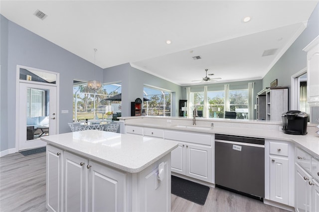 kitchen featuring white cabinets, light countertops, dishwasher, and a sink