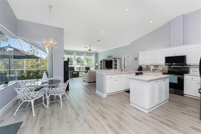 kitchen featuring pendant lighting, light countertops, electric range, open floor plan, and a peninsula